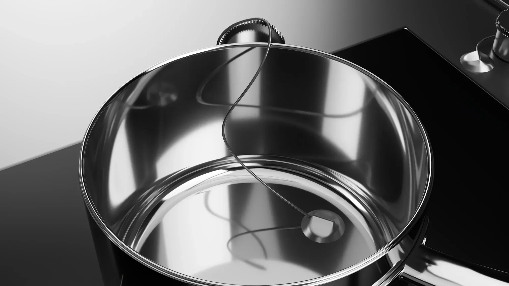 Steel pot on the induction cooktop next to the probe's storage tray