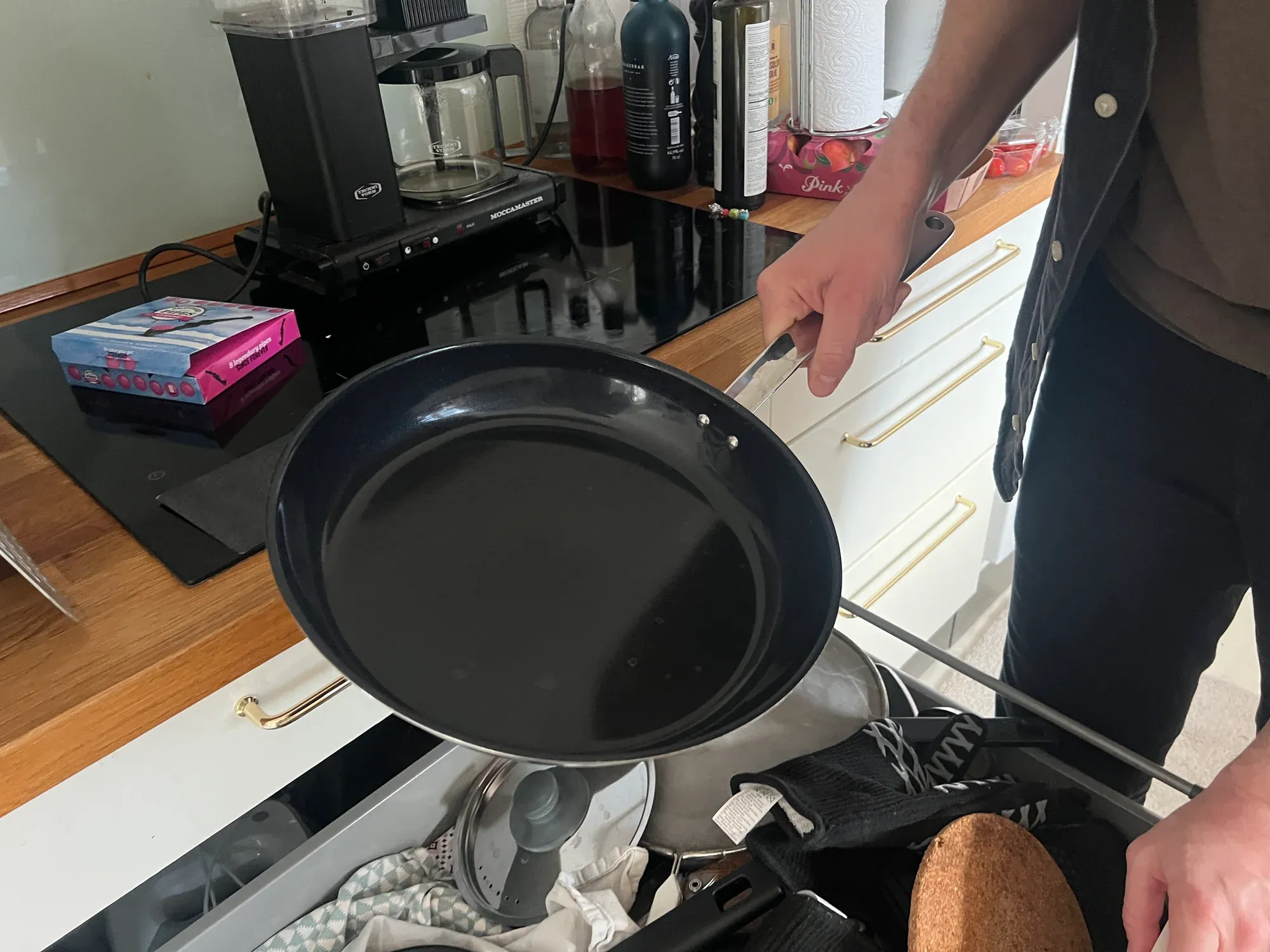 A home cook holding their favorite pan in their kitchen